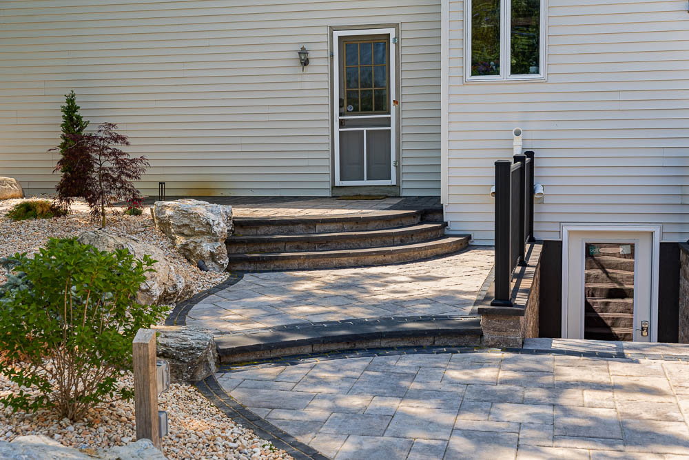 Patio steps beside planting beds and boulders
