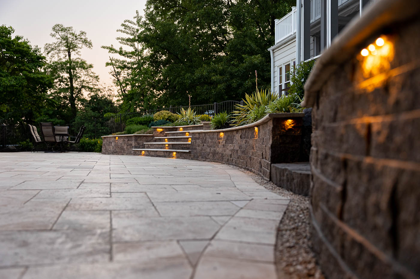 paver patio with a retaining wall with lights